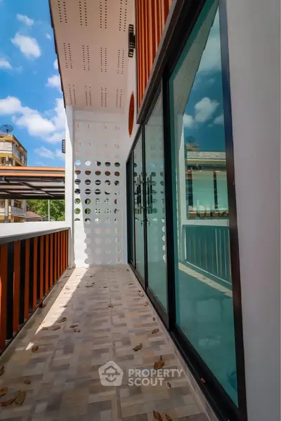 Modern balcony with glass doors and stylish design, perfect for enjoying sunny days.