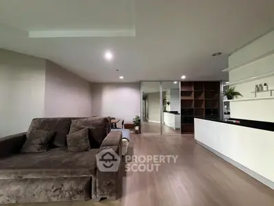 Modern open-plan living room with sleek kitchen and cozy sofa, perfect for contemporary living.