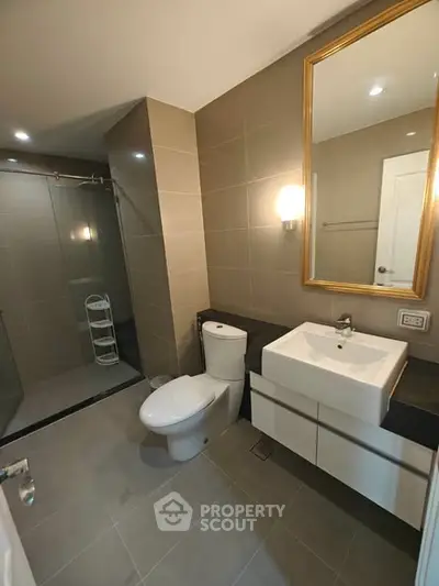 Modern bathroom with sleek fixtures and spacious shower in a contemporary home.