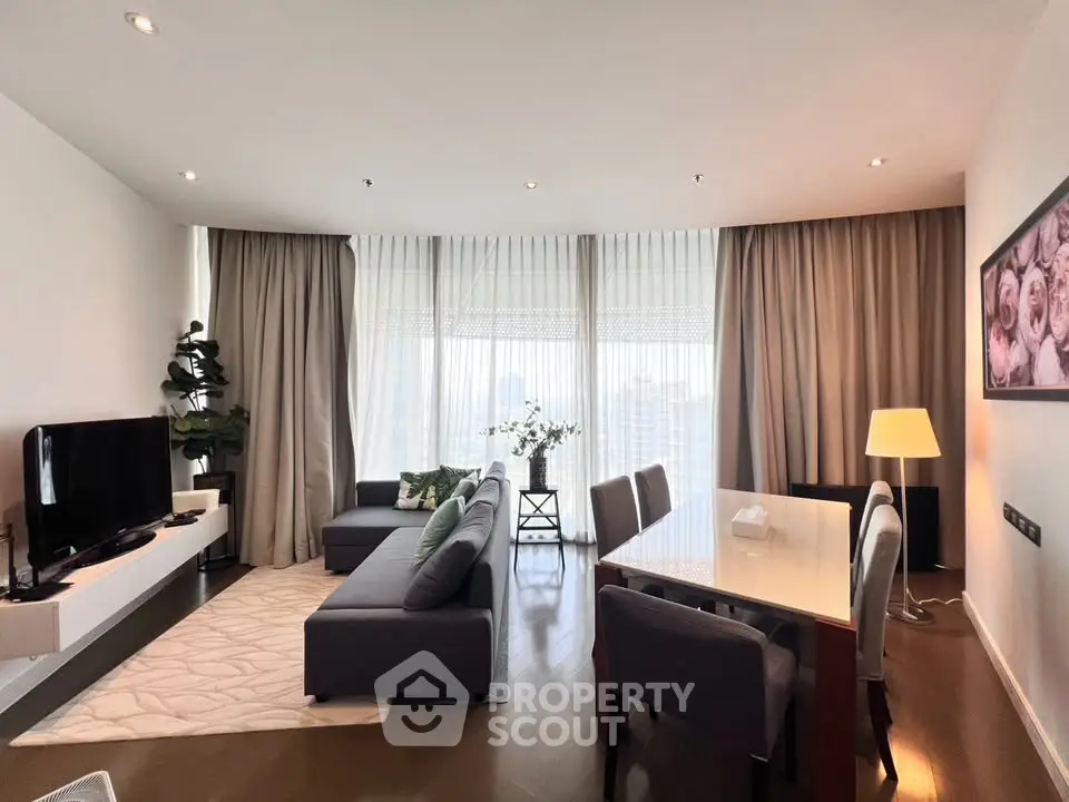 Spacious modern living room with elegant decor and large windows offering city views.