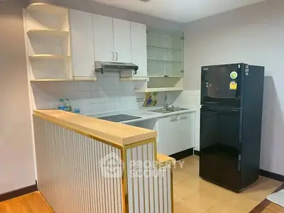 Modern kitchen with sleek black fridge and stylish cabinetry