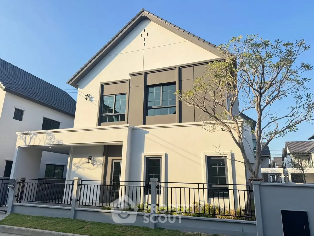 Modern two-story house with sleek design and landscaped front yard.