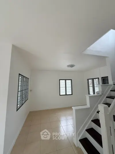 Spacious interior with tiled flooring and staircase, ideal for modern living.