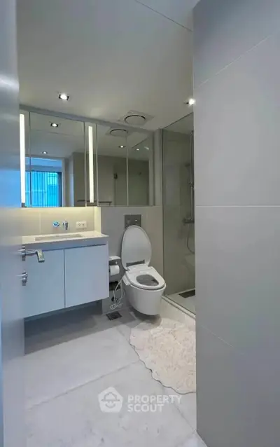 Modern bathroom with sleek fixtures and large mirrors in a contemporary apartment.