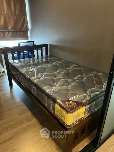 Cozy bedroom with single bed and wooden flooring, perfect for a minimalist lifestyle.