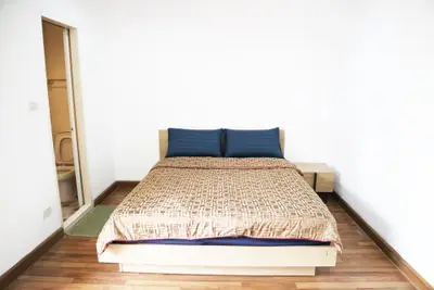 Cozy bedroom with wooden flooring and modern design, featuring an ensuite bathroom.