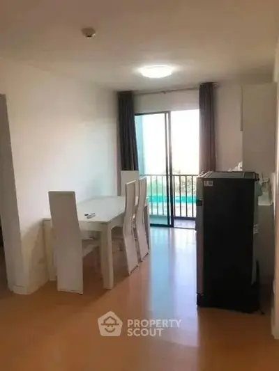 Modern dining area with sleek furniture and balcony view in a bright apartment.