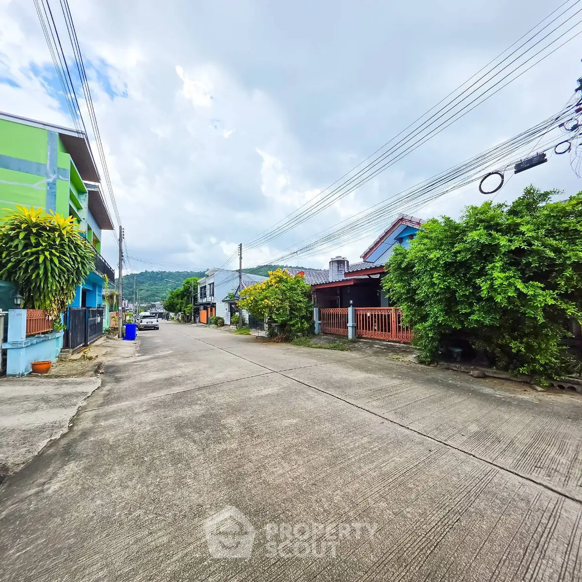 Charming residential street with lush greenery and mountain views, perfect for serene living.