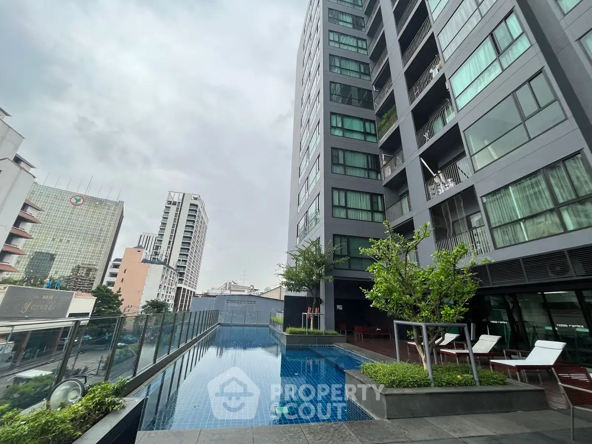 Modern high-rise building with rooftop pool and city view