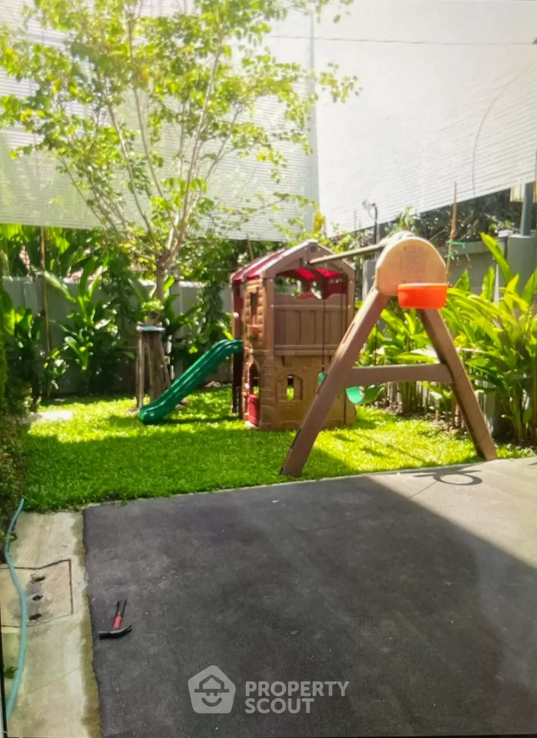 Charming backyard with playset and lush greenery, perfect for family fun and relaxation.