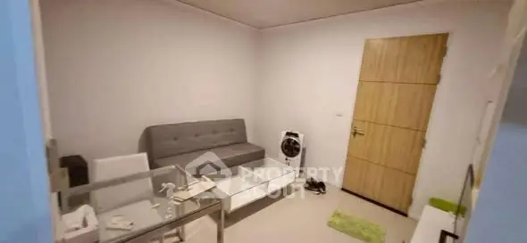 Cozy living room with modern sofa and glass coffee table, perfect for relaxation.