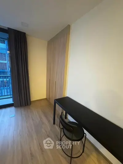 Modern study room with sleek desk and chair, featuring a large window and built-in wardrobe.