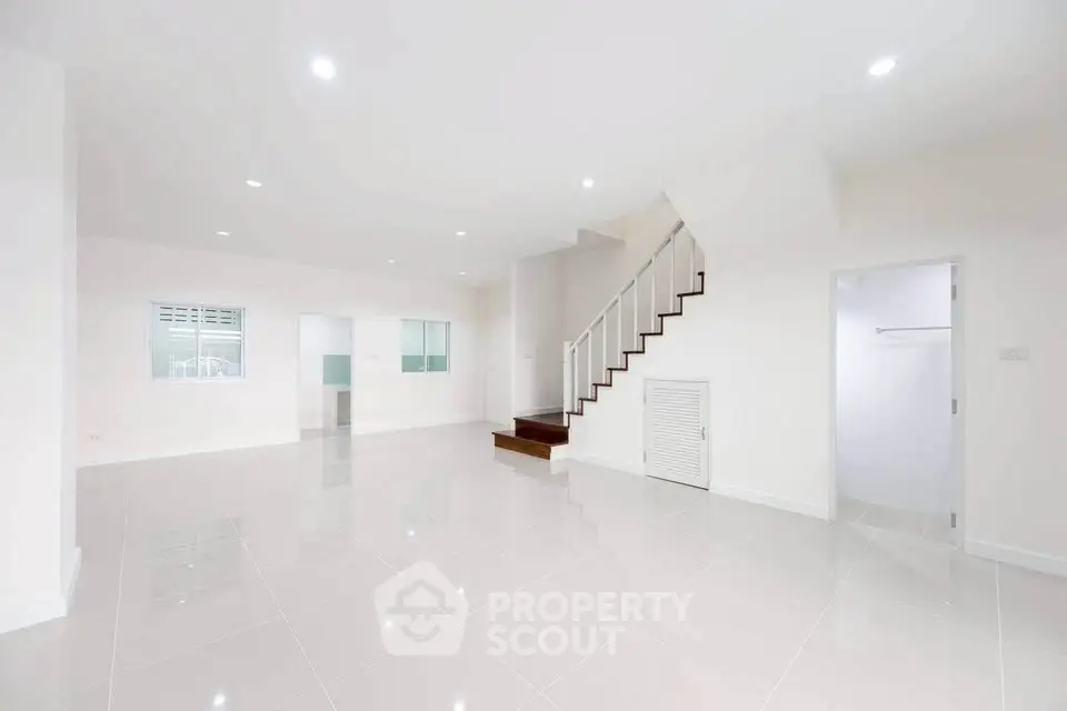 Spacious modern living room with sleek staircase and glossy tile flooring