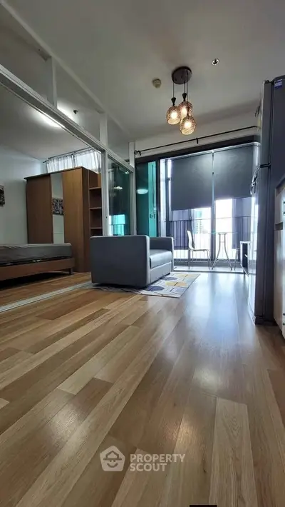 Modern open-plan living room with stylish lighting and balcony access