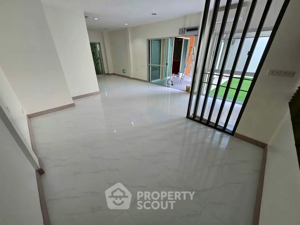 Spacious modern living room with sleek flooring and large windows for natural light.