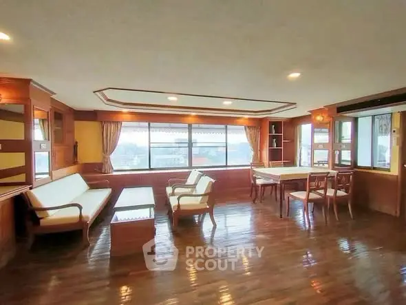 Spacious living room with wooden flooring and large windows offering a panoramic view.
