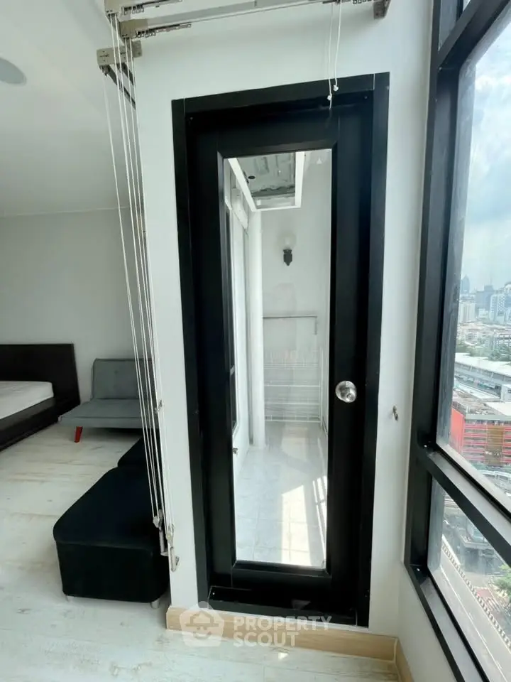 Modern apartment with sleek balcony access and panoramic city views, featuring stylish interior design and ample natural light.