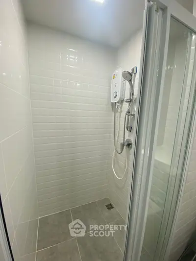 Modern bathroom shower with sleek white tiles and glass door enclosure