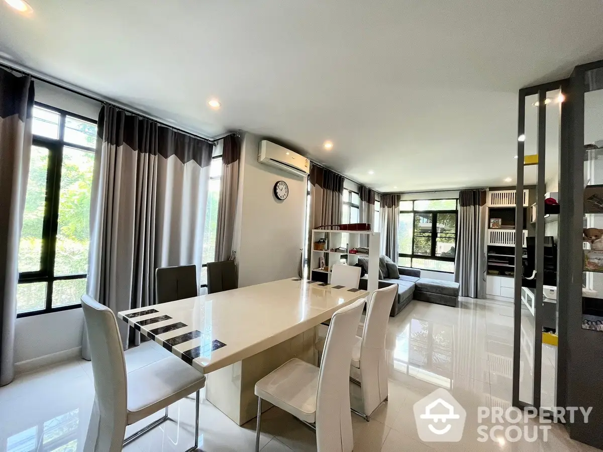 Spacious modern dining area seamlessly connected to a stylish kitchen with state-of-the-art appliances, ample natural light, and elegant interior design.