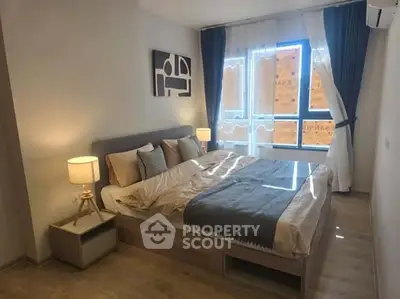 Modern bedroom with stylish decor and large window for natural light.