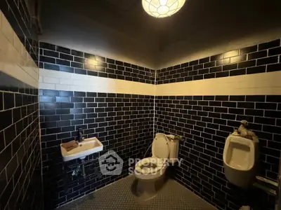 Stylish modern bathroom with black subway tiles and ambient lighting