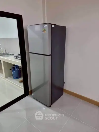 Modern kitchen with sleek stainless steel refrigerator and gas stove setup.