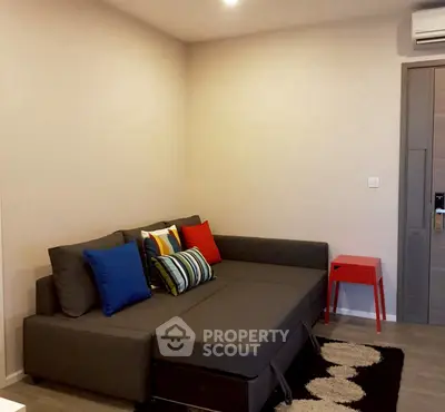 Modern living room with stylish gray sofa and colorful cushions, featuring a cozy ambiance.