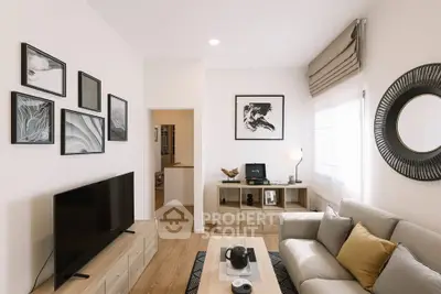 Modern living room with stylish decor, large TV, and cozy seating area.