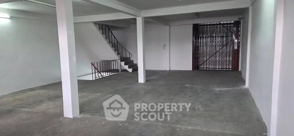 Spacious open-plan interior with staircase and secure gate, ideal for versatile use.