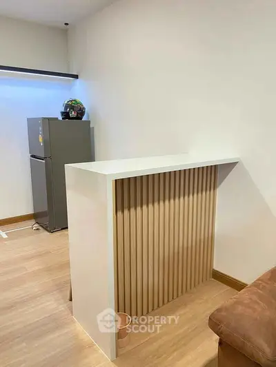 Modern interior with sleek fridge and stylish partition in cozy living space.