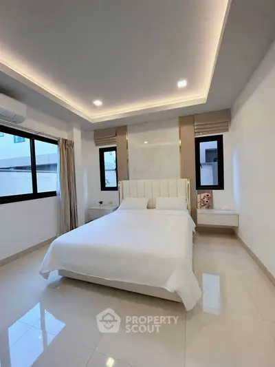 Elegant bedroom with modern lighting and large windows in a stylish home.