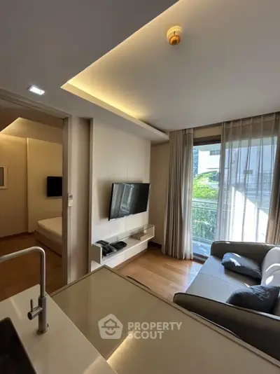 Modern living room with sleek design and natural light, featuring a cozy sofa and wall-mounted TV.