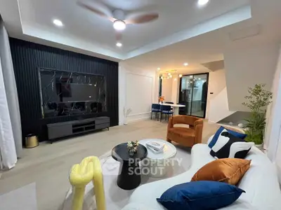 Modern living room with stylish decor and open layout, featuring a cozy seating area and elegant lighting.