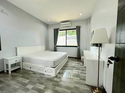 Spacious bedroom with modern furnishings and natural light