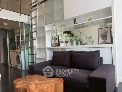 Modern loft apartment with stylish living room and mezzanine, featuring a cozy sofa and unique wooden coffee table.