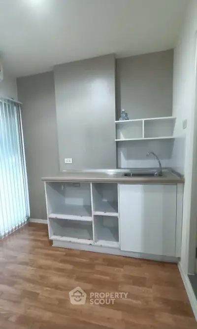 Modern kitchen with sleek cabinetry and wooden flooring, perfect for compact living spaces.