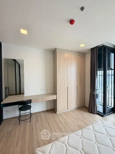 Modern bedroom with wooden flooring, built-in wardrobe, and large windows for natural light.