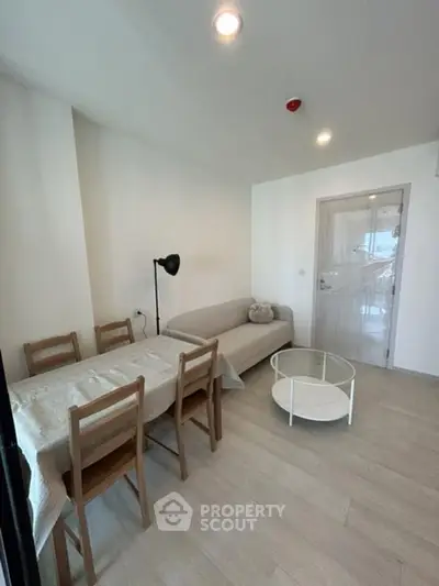 Modern living room with cozy sofa, dining table, and stylish decor in a bright apartment.