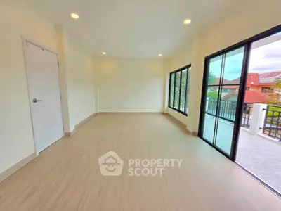Spacious empty room with large windows and balcony access, perfect for customization.