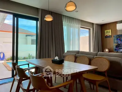 Modern living room with pool view, elegant dining set, and stylish lighting in a luxurious home.