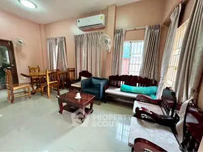 Spacious living room with elegant wooden furniture and air conditioning, perfect for family gatherings.