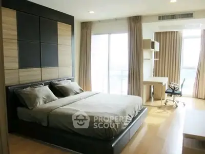 Spacious modern bedroom with large windows and study area, perfect for comfort and productivity.