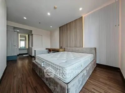 Spacious modern bedroom with elegant wood flooring and stylish bed frame