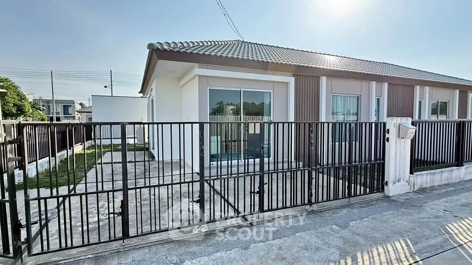 Charming single-story home with gated driveway and modern exterior design.