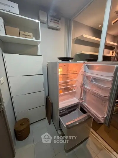 Modern kitchen with open fridge and sleek storage cabinets