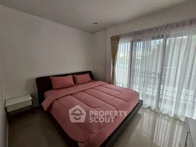 Cozy bedroom with large window and pink bedding in modern apartment