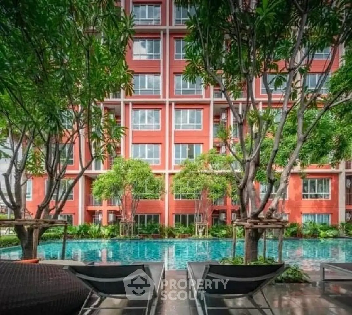 Luxurious apartment building with a stunning pool and lush greenery, perfect for relaxation and modern living.