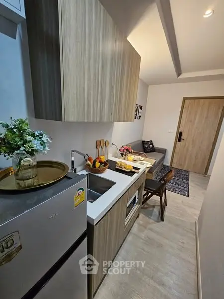 Modern compact kitchen with sleek wooden cabinets and cozy dining area