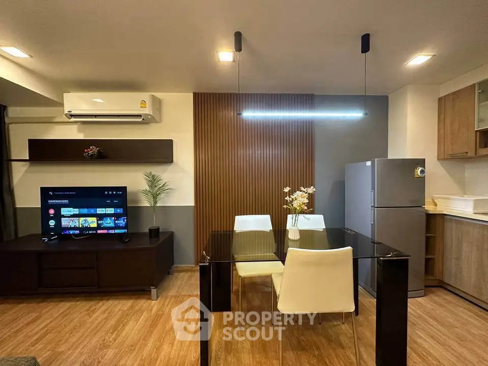 Modern living room with sleek furniture and stylish decor, featuring a dining area and entertainment setup.