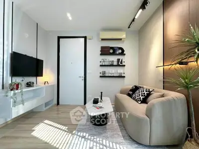 Modern living room with stylish decor and natural light, featuring a cozy sofa and wall-mounted TV.